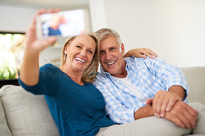 Buy stock photo Cropped shot of a mature couple taking a selfie together at home