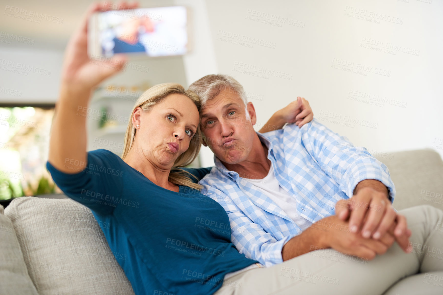 Buy stock photo Cropped shot of a mature couple taking a selfie together at home