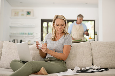 Buy stock photo Shot of a mature woman paying her bills online