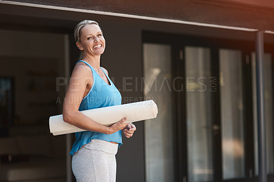 Buy stock photo Shot of a mature and happy woman holding a yoga mat and getting ready to do yoga