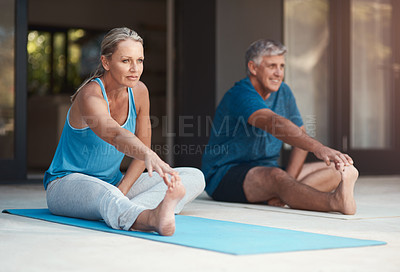 Buy stock photo Shot of a mature and happy couple stretching before they do yoga outside of their home