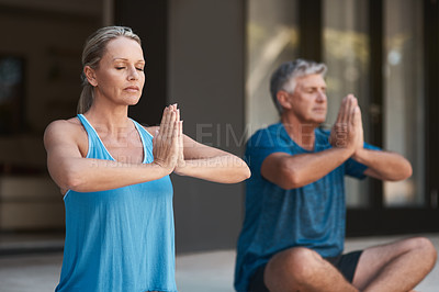 Buy stock photo Shot of a mature couple peacefully engaging in a yoga pose with legs crossed and hands put together
