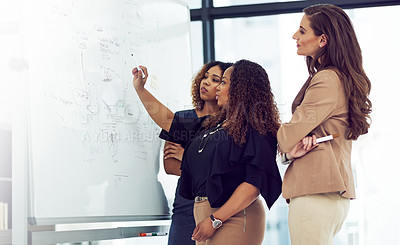 Buy stock photo Cropped shot of a group of businesswomen working on a whiteboard in the boardroom