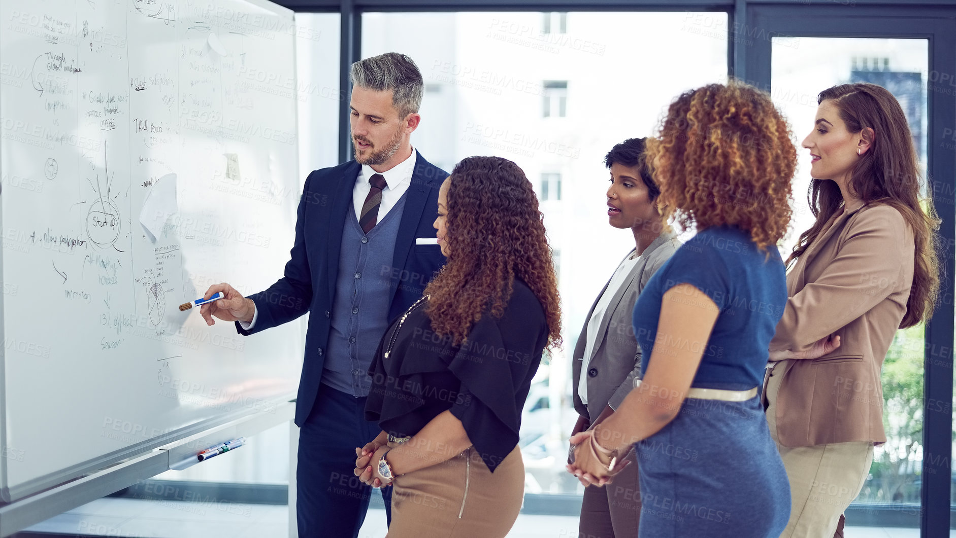 Buy stock photo Cropped shot of a group of businesspeople working on a whiteboard in the boardroom