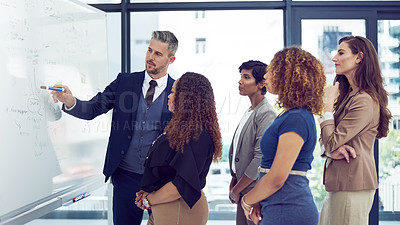 Buy stock photo Cropped shot of a group of businesspeople working on a whiteboard in the boardroom