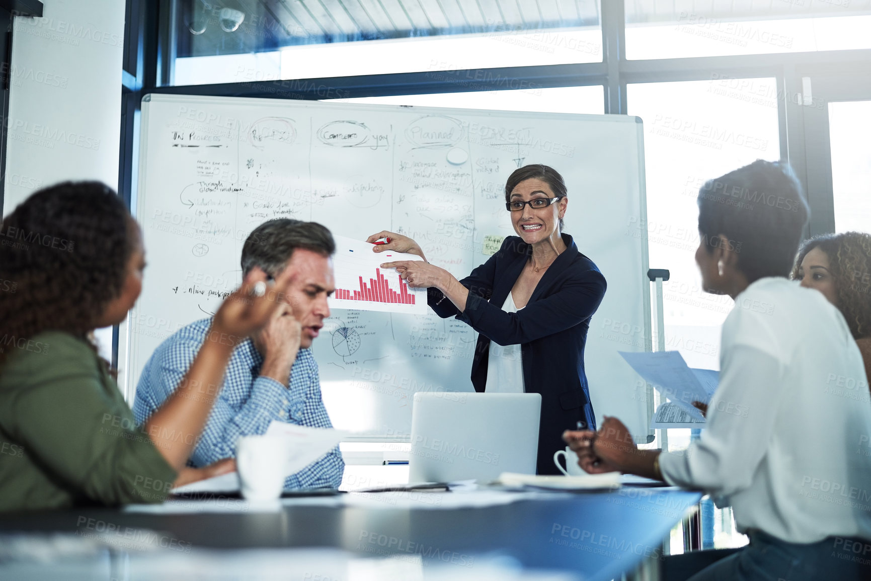 Buy stock photo Shot of a stressed businesswoman losing her temper during a meeting with her colleagues in the boardroom