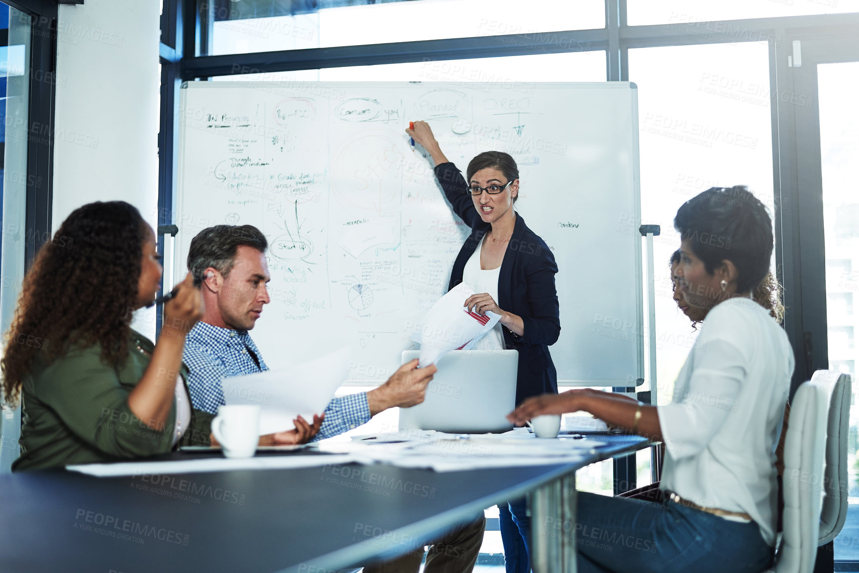 Buy stock photo Shot of a stressed businesswoman losing her temper during a meeting with her colleagues in the boardroom