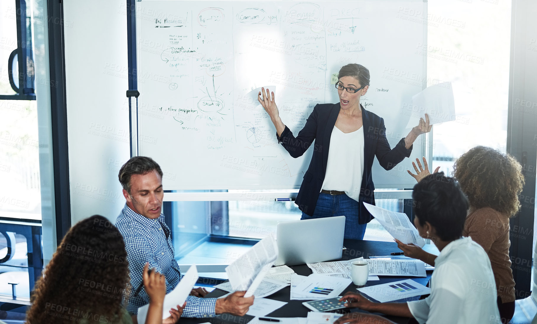 Buy stock photo Shot of a stressed businesswoman losing her temper during a meeting with her colleagues in the boardroom