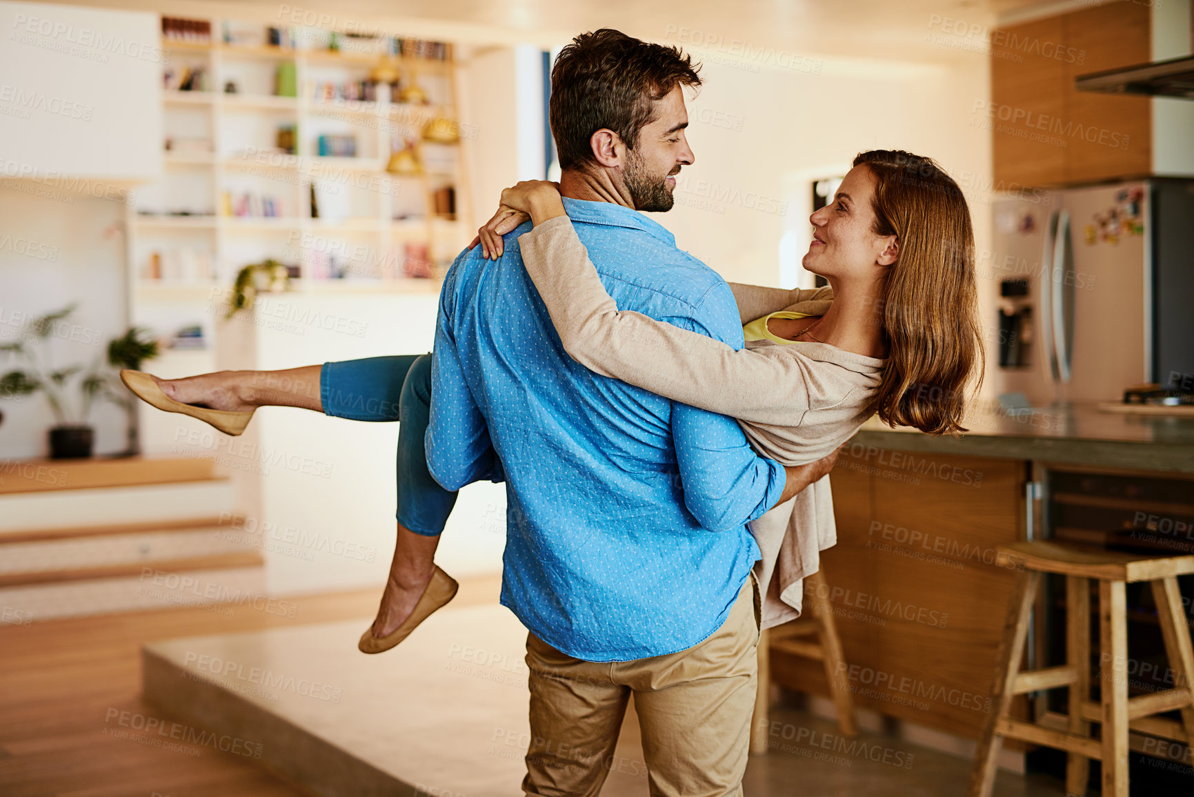 Buy stock photo Couple, carrying and smile in new home, care and mortgage for people from honeymoon, together and relationship. Moving, man and woman in house with loan, marriage and investing on future with partner