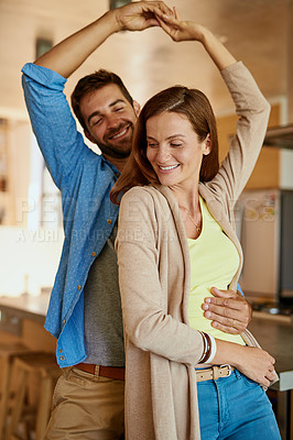 Buy stock photo Cropped shot of an affectionate young couple dancing in their kitchen
