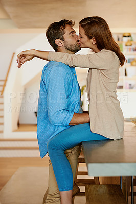 Buy stock photo Cropped shot of an affectionate young couple kissing in their kitchen