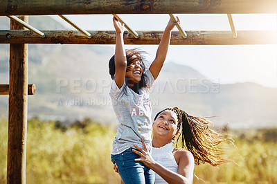 Buy stock photo Cropped shot of a mother holding her daughter as she climbs a jungle gym at the park