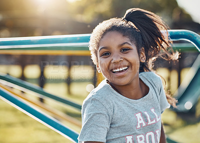 Buy stock photo Portrait of an adorable little girl playing on a merry-go-round at the park