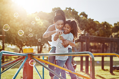 Buy stock photo Cropped shot of a mother and her daughter blowing bubbles at the park