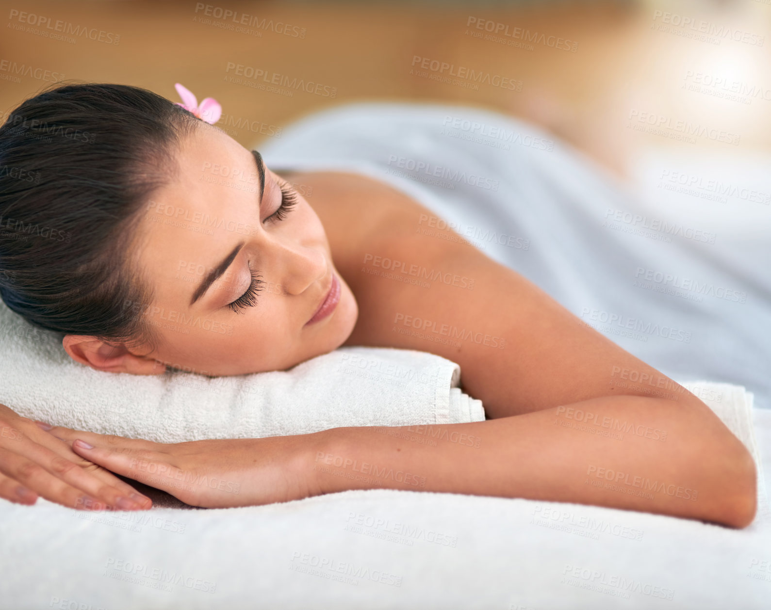 Buy stock photo Cropped shot of an attractive young woman relaxing on a massage table at a spa