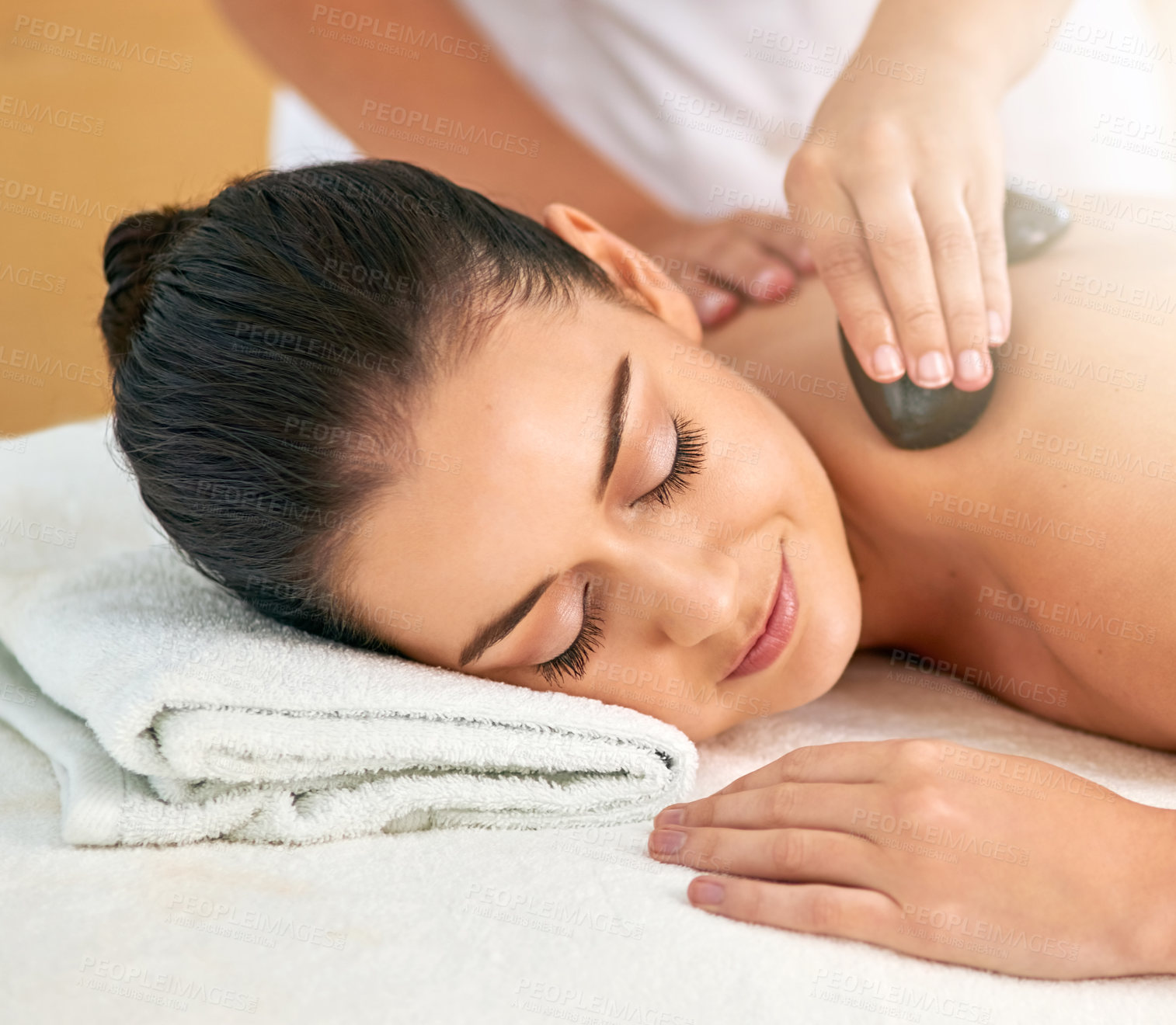 Buy stock photo Cropped shot of an attractive young woman enjoying a hot stone massage at a spa