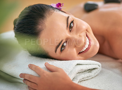 Buy stock photo Portrait of an attractive young woman enjoying a hot stone massage at a spa