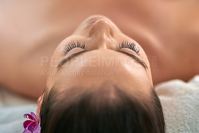 Buy stock photo Cropped shot of an attractive young woman relaxing on a massage table at a spa