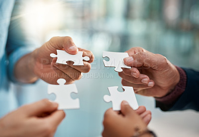 Buy stock photo Cropped shot of a group of unrecognizable businesspeople putting puzzle pieces together in the office