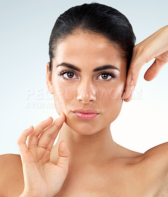 Buy stock photo Studio shot of an beautiful young woman feeling her skin against a gray background