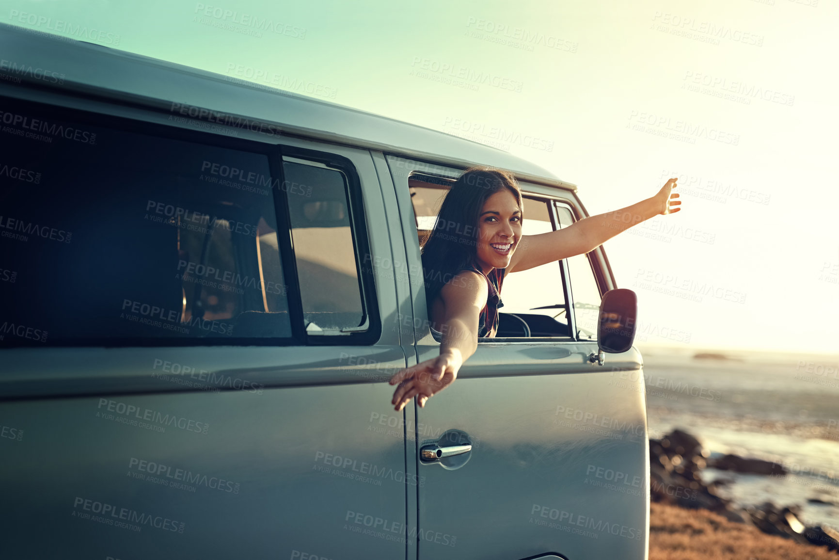 Buy stock photo Shot of a young woman leaning out of her van's window with her arms outstretched