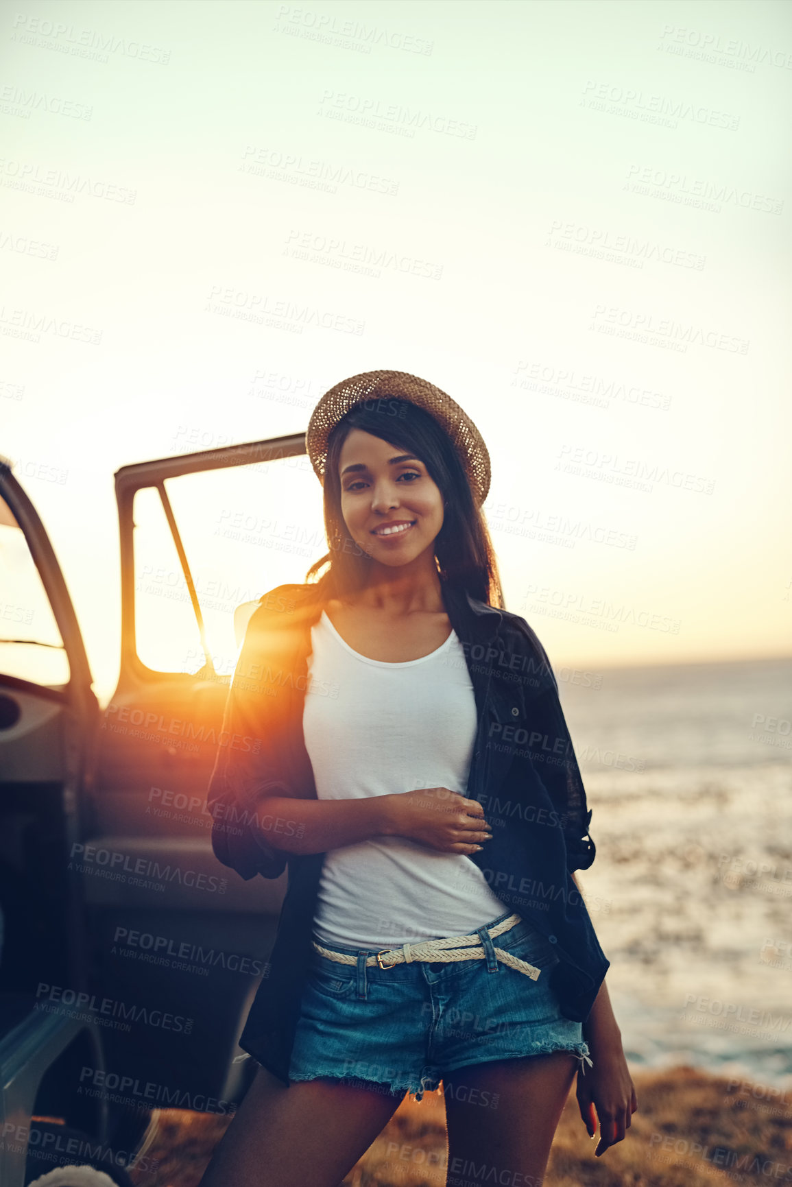 Buy stock photo Woman, portrait and car for road trip, sunset and adventure at beach with water, sky and ocean view. Female person, smile and van for travel, dusk and journey outdoor with happiness, relax and peace