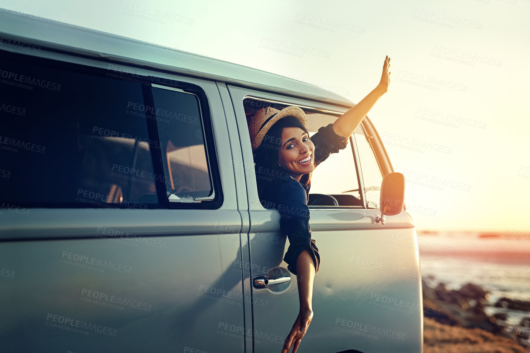Buy stock photo Shot of a young woman leaning out of her van's window with her arms outstretched