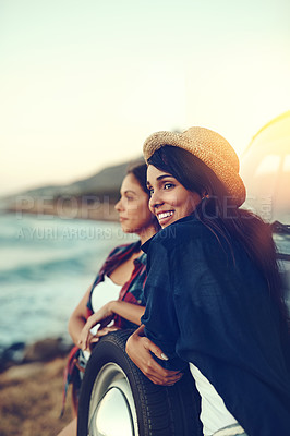 Buy stock photo Shot of two young friends stopping at the beach during their roadtrip