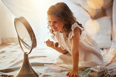 Buy stock photo Shot of an adorable little girl applying blusher on her face in the mirror