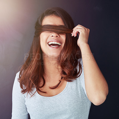 Buy stock photo Cropped shot of a beautiful young woman posing with her hair over her eyes in the studio