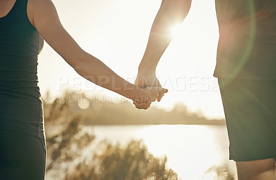 Buy stock photo Shot of a couple holding hands outdoors