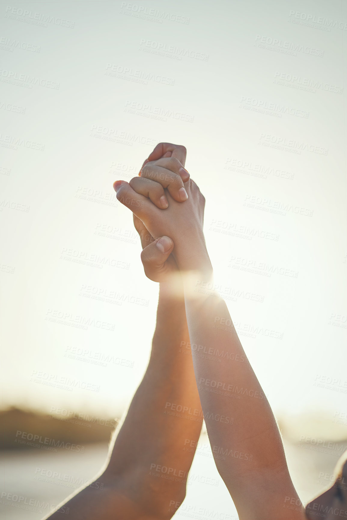 Buy stock photo Shot of a couple holding hands and arms raised outdoors