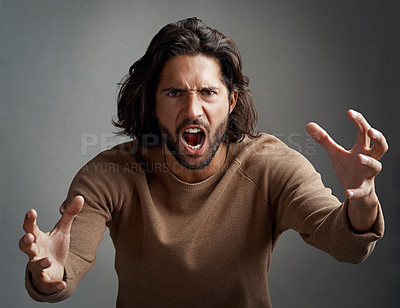 Buy stock photo Studio shot of a young man screaming in anger against a gray background