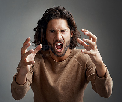 Buy stock photo Studio shot of a young man screaming in anger against a gray background