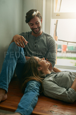 Buy stock photo Shot of an affectionate young couple talking to one another and smiling