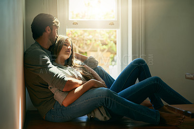 Buy stock photo Shot of an affectionate young couple holding each other in the sunlight