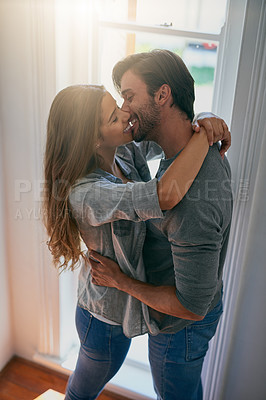 Buy stock photo Shot of an affectionate young couple sharing a kiss and holding each other