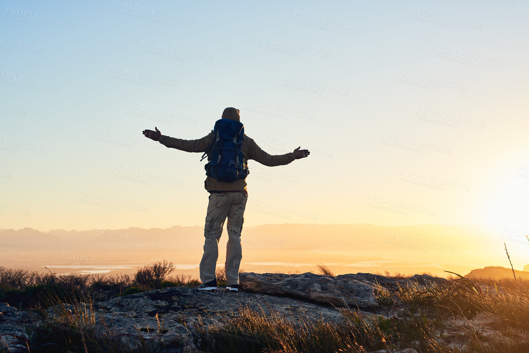 Buy stock photo Mountain top, sunset and person with hiking achievement, freedom and trekking vacation with backpack. Sky, view and back of hiker with arms raised on cliff for outdoor adventure holiday in nature