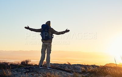 Buy stock photo Shot of a hiker arms raised standing on top of a mountain