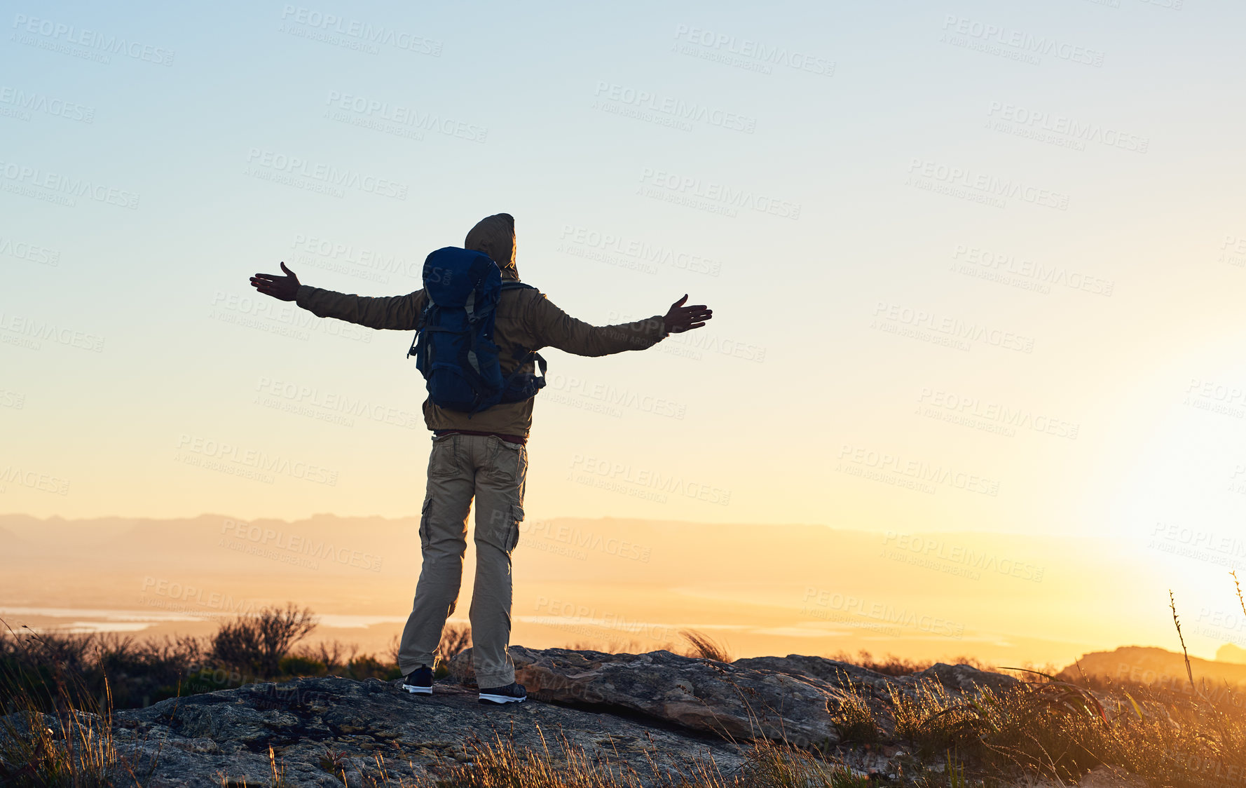 Buy stock photo Mountain, sunset sky and person with hiking achievement, freedom or trekking vacation with backpack. Heaven, prayer and hiker with arms raised on cliff for outdoor adventure holiday success in nature