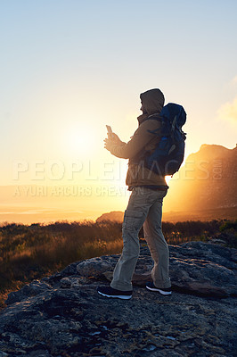 Buy stock photo Shot of a hiker taking a photo with his cameraphone on top of a mountain