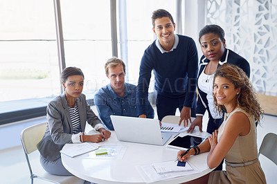 Buy stock photo Portrait of a team of smiling businesspeople working on a laptop together at a table in the office