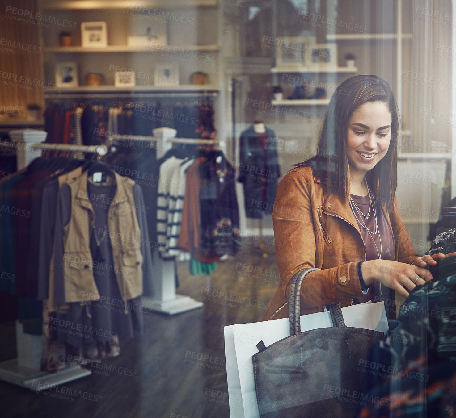 Buy stock photo Shot of a young woman shopping at a clothing store