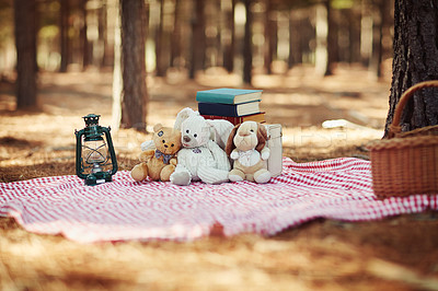 Buy stock photo Shot of teddybears sitting on a picnic blanket in the woods