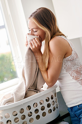 Buy stock photo Young, woman and clothes smell laundry in basket is happy cloth is clean in the kitchen in apartment. Female person, fabric scent and cleaning for housework with happiness at home in a laundry room. 