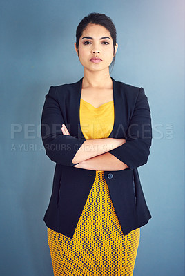 Buy stock photo Studio portrait of an attractive young businesswoman standing against a blue background