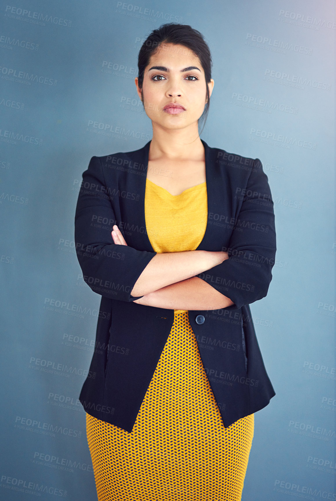 Buy stock photo Studio portrait of an attractive young businesswoman standing against a blue background