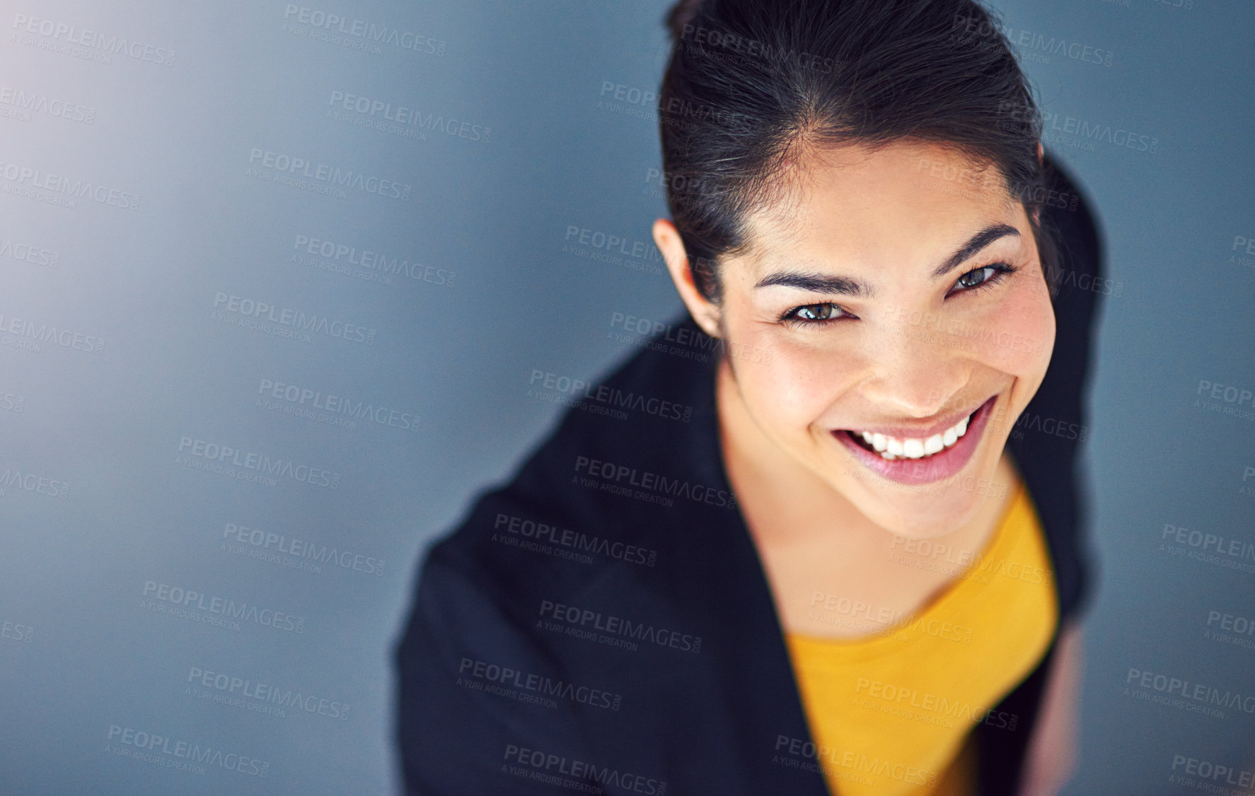 Buy stock photo Studio portrait of an attractive young businesswoman standing against a blue background