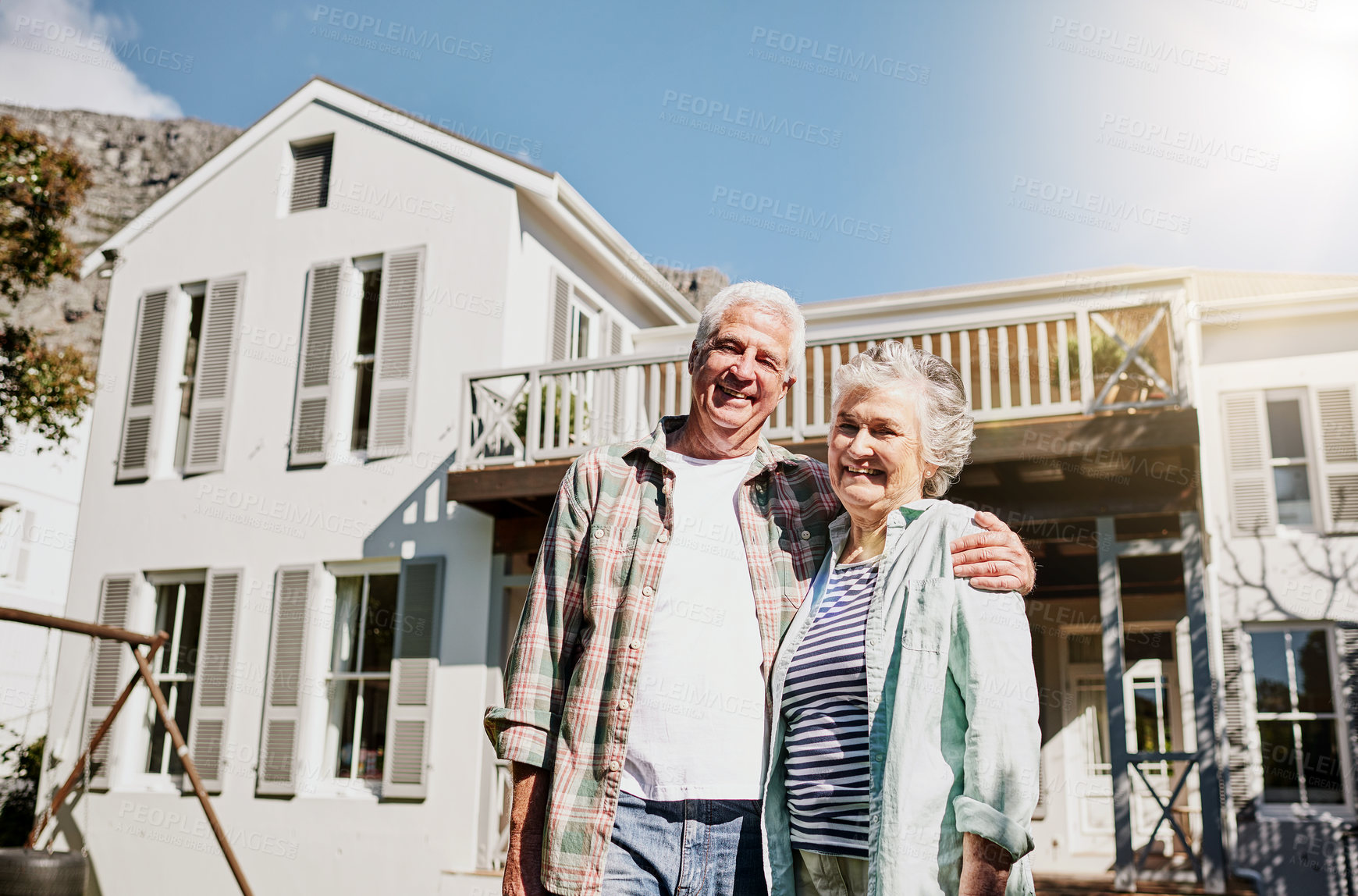 Buy stock photo Shot of a happy senior couple standing together in front of their house