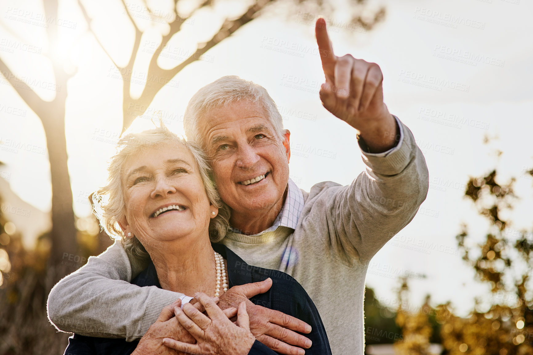 Buy stock photo Shot of a happy senior man pointing something out to his wife outdoors